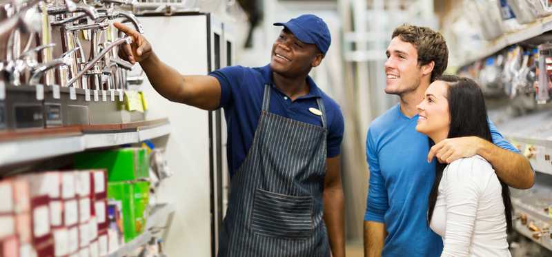 A store employee helps customers.