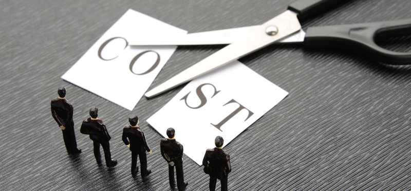 Scissors cutting a postcard that reads Cost in half.