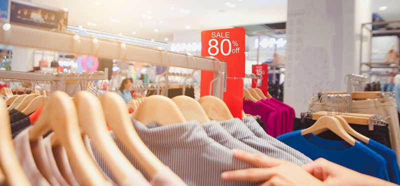 Racks of clothing showing a sale of 80 percent off.