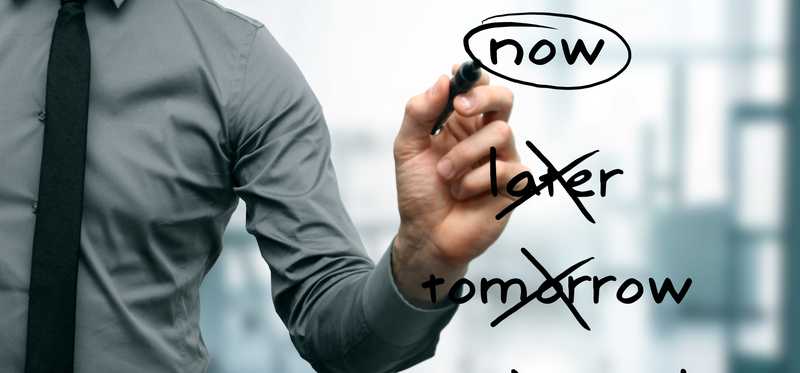 A businessman crossing out the words Later, Tomorrow, and Next Week and circling the word Now