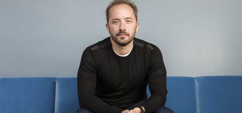 Drew Houston sitting on a blue couch.