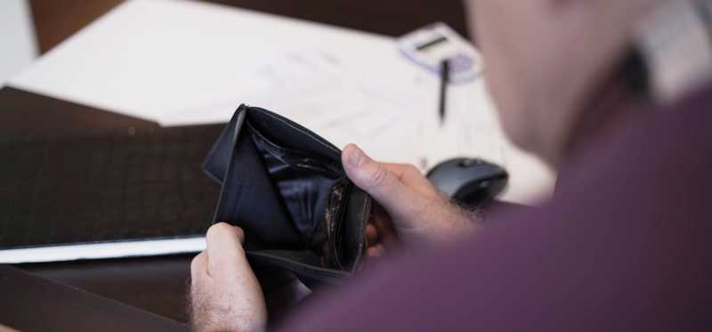 Person opening up an empty wallet.