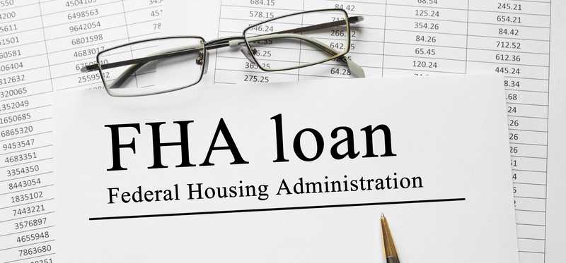 Charts with a piece of paper lying on top that says Federal Housing Administration FHA loan.