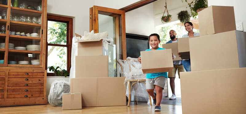 A relocating family is moving boxes into their new home.