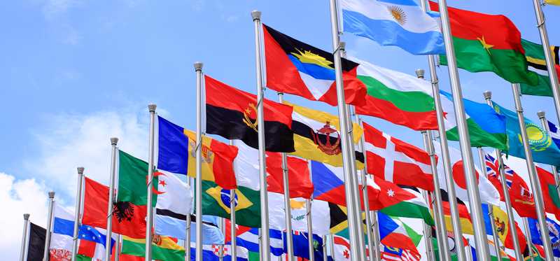 Lots of flagpoles flying flags of different countries.