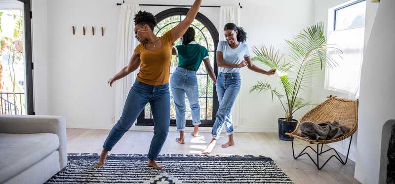 People dancing in the living room of a house.