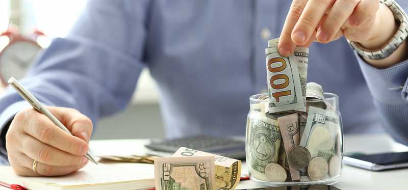 Person putting money into a jar.