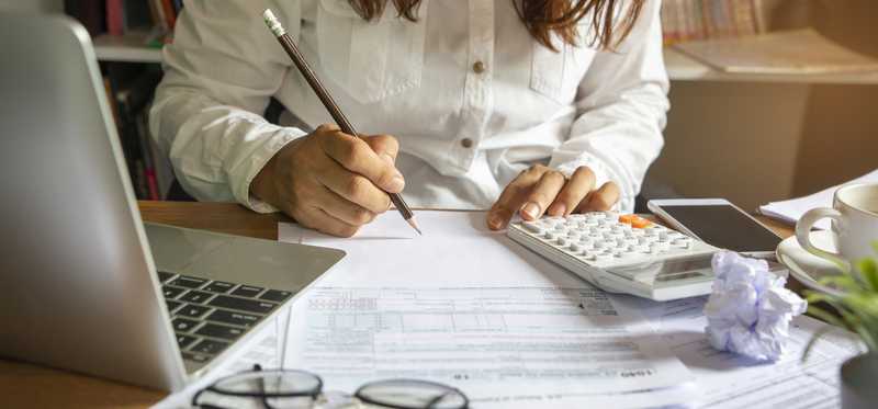 Person sitting at desk computing taxes.