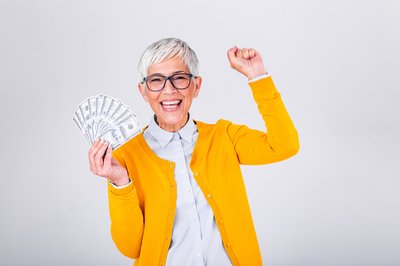 Person holding money and cheering.