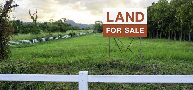 For Sale sign in large vacant lot.