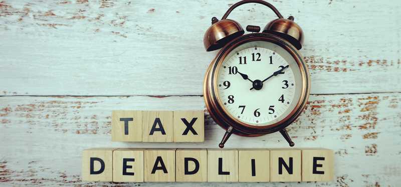 An alarm clock with blocks under it spelling out Tax Deadline.