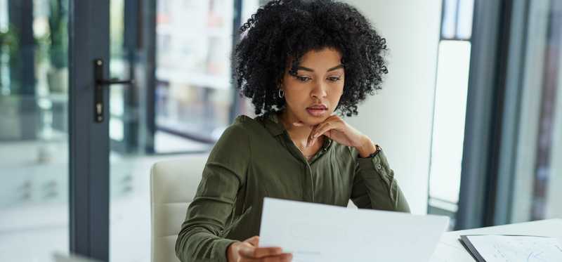 Shot of a person going over paperwork in a modern office.