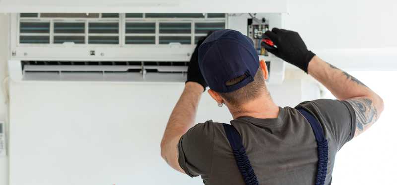 Person working on air conditioner.