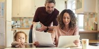 Family looking at paperwork at their kitchen table.