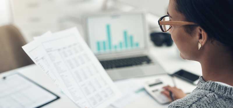Person sitting at desk and looking at income statements.