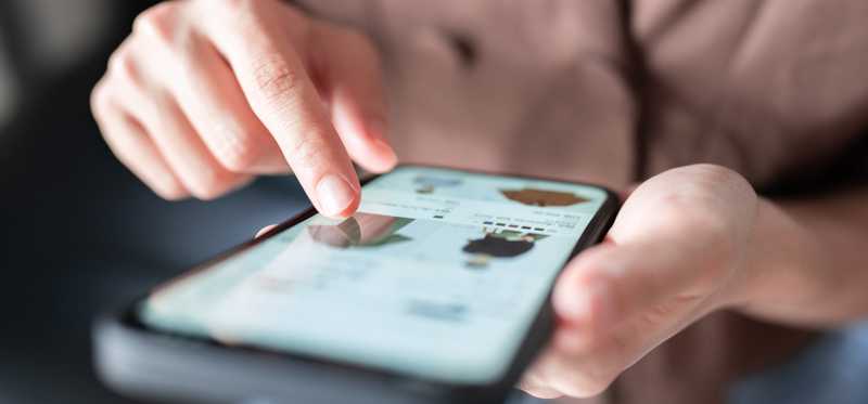 Person shopping for clothes on mobile phone.
