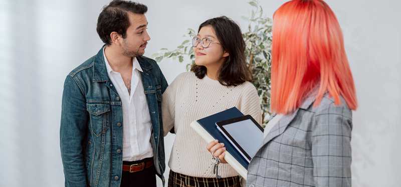 People looking at rental property or home with property manager or real estate agent.