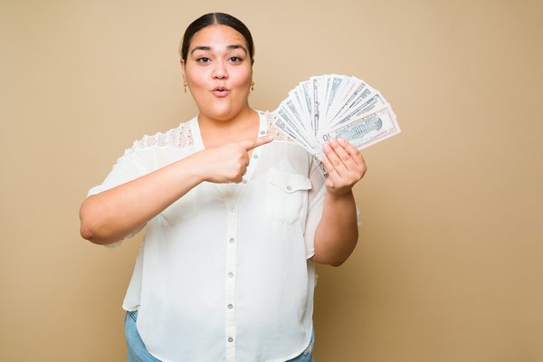 woman holding fan made of cash