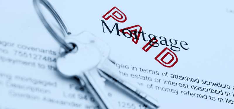 Keys sitting on top of mortgage paperwork stamped Paid.