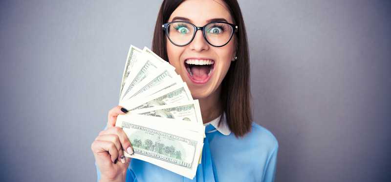 Person in glasses holding money and smiling widely.