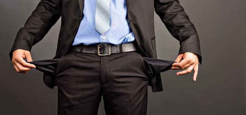 Person in a business suit showing empty pockets
