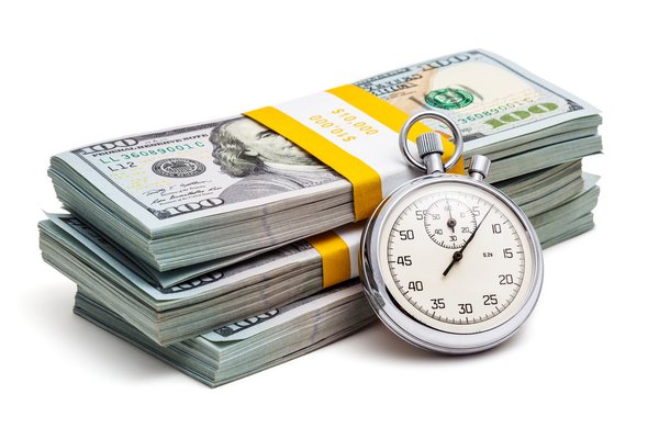 Stopwatch resting on pile of money