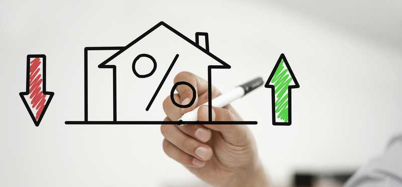 Hand drawing house with a green arrow pointed up and a red one down to represent fluctuating mortgage rates.