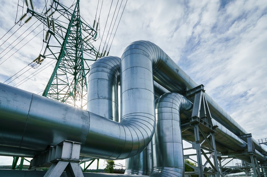 Industrial pipelines on pipe-bridge against blue sky