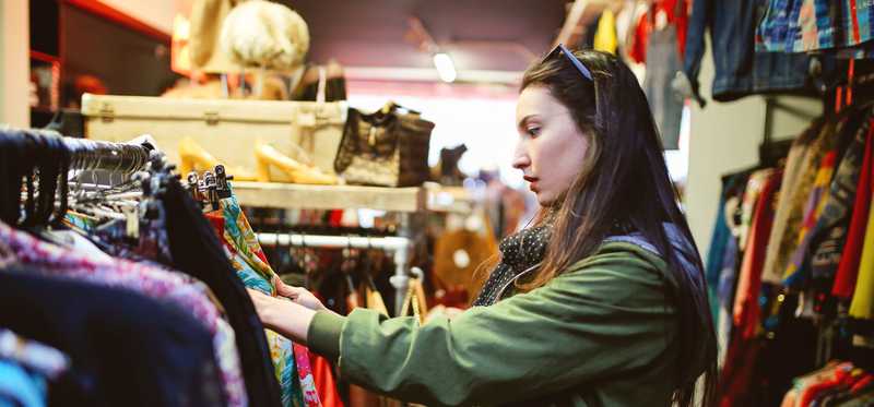 Person in secondhand store is shopping for clothes.