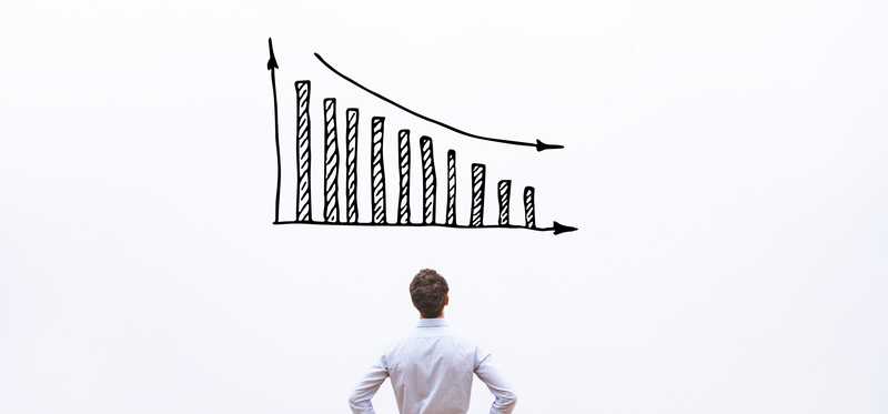 Person looking at a declining bar chart drawn on a wall.