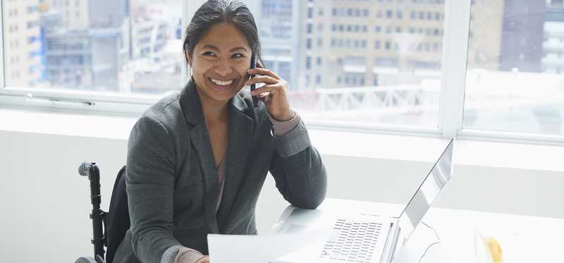 Person who uses a wheelchair is working at a desk.