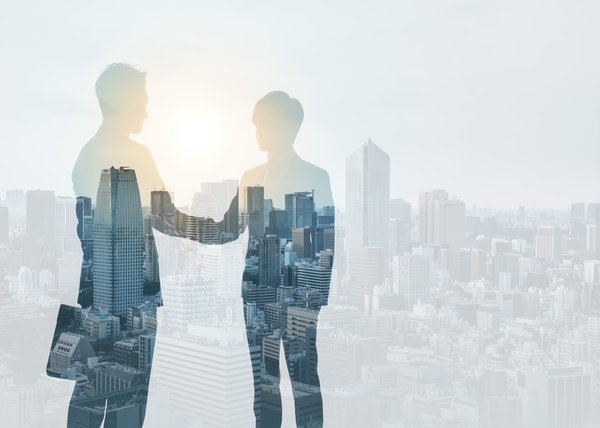 two people's silhouettes over a cityscape