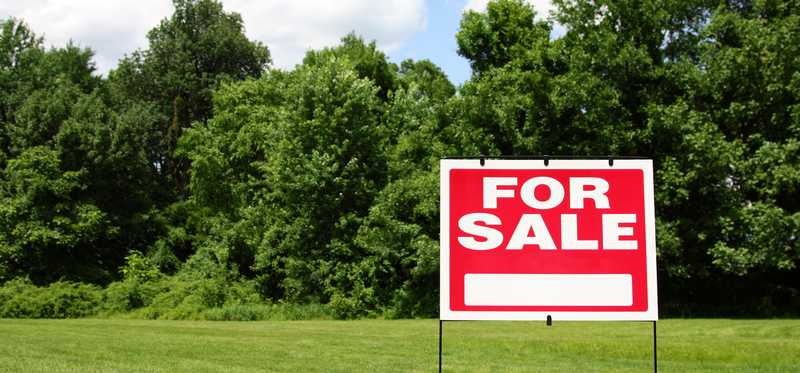 For Sale sign on vacant lot.