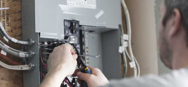 Person working on electrical box in a home.