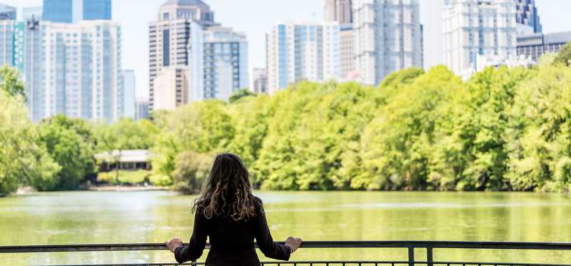 Person in park looking at the Atlanta city skyline.
