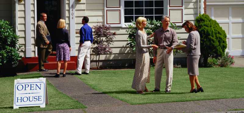 A house with an Open House sign and people in the front yard.
