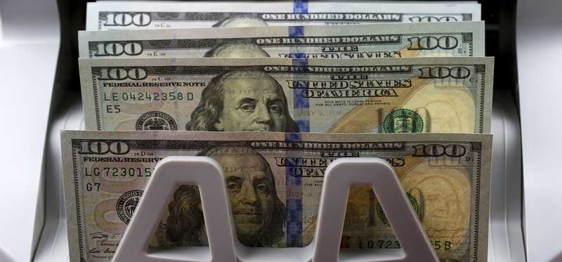 Bundles of cash being dispensed by an ATM.