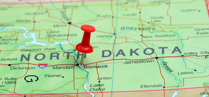 We see a closeup of a map of North Dakota, with a pin stuck in Bismarck.