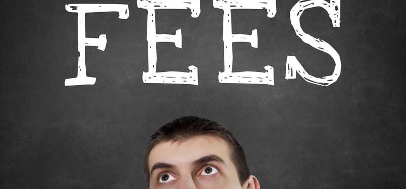 "Fees" written on a blackboard above a man's forehead.