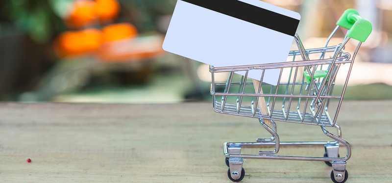 Credit card inside a small shopping cart.