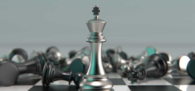 A king piece in a chess game stands alone, with other pieces toppled.