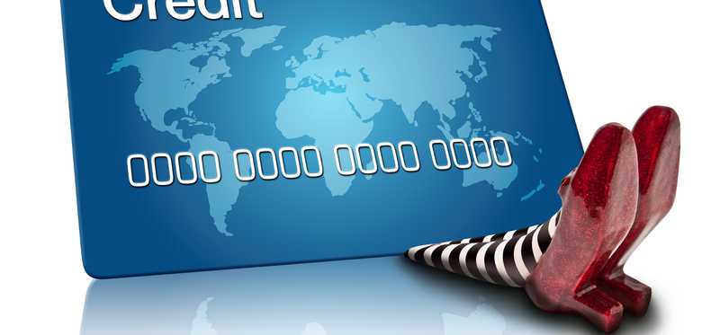 A credit card has seemingly fallen on and crushed someone, with only feet sticking out from under it.