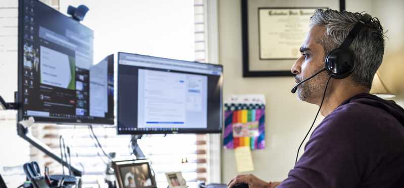 Person looking at multiple computer monitors.