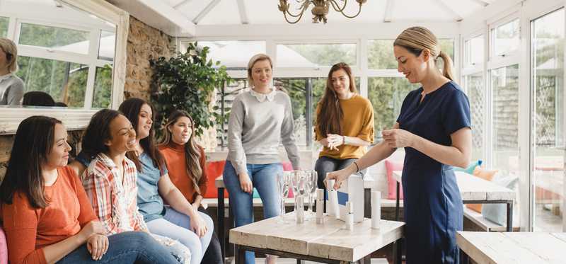 A party where one person is showing products displayed on a table.