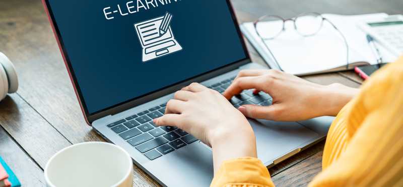 We see an image of an open laptop, with the word e-learning on its screen.