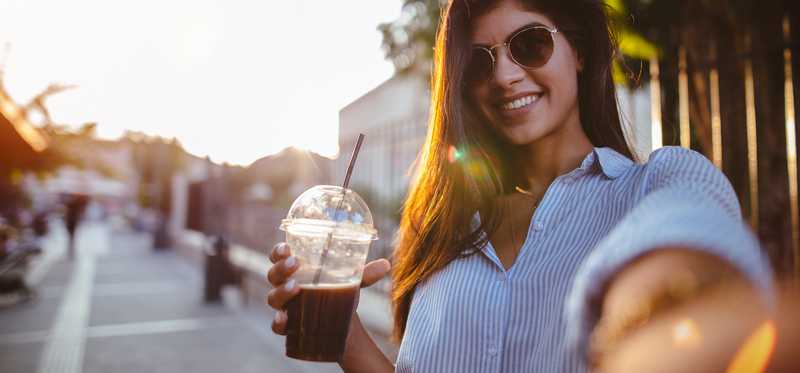 Smiling woman with an iced coffee