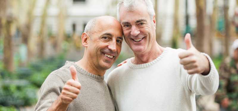 We see a couple looking at the camera, with thumbs up.