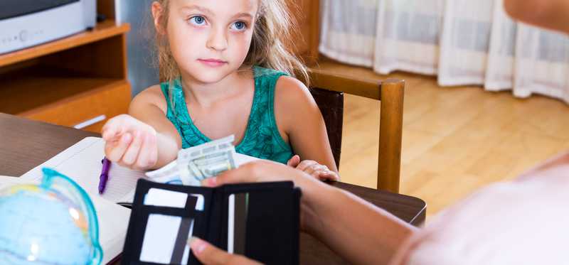 A young girl is getting some cash as an allowance.