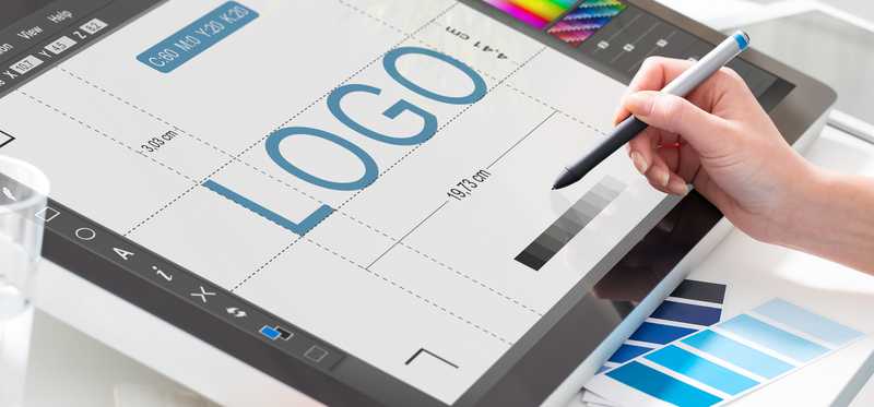 We see someone designing a logo on a tablet -- starting with the word LOGO.