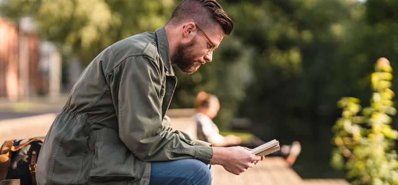Person sitting outdoors and reading.